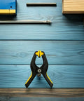 Eight Pack LCD Screen Fastening Clamps With Scratch Free Sponge Pads, single clamp with yellow and black grips on blue surface.
