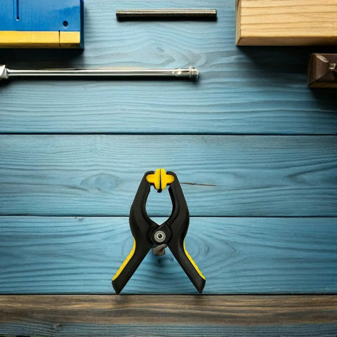 Eight Pack LCD Screen Fastening Clamps With Scratch Free Sponge Pads, single clamp with yellow and black grips on blue surface.