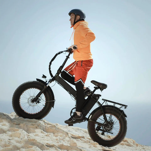 Person riding fat bike with Two-Pack 20x4 Fat Bike Tubes With 32mm AV32 Schrader Valve For 20 Inch Fat Tires on rocky terrain