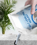 Heavy Duty Concrete Crack Filler To Fix Cracked Pavement And Asphalt Fast While Delivering A Waterproof Shield Against Seasonal Swelling Using Elastic Polymers For Badass Repair Results That Handle Extreme Temps Like A Boss And Stop Leaks Dead In Their. A hand holding a 400ml tube of concrete crack filler, positioned over a cracked surface.