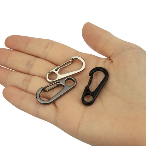 Hand holding three Mini Carabiner Clip 10 Pack Aluminum Alloy Tiny Spring Snap Hooks For Paracord EDC Keychains And Backpack Gear Black