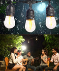 50 Foot Solar Outdoor String Lights With Remote feature shatterproof Edison LED bulbs in garden patio setting at night