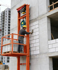 Heavy Duty Electric Freight Workhorse Featuring Quiet Hydraulic Wall Mounted Vertical Hoist, 16 Foot Travel Height, 2200 Lb Capacity in use at a construction site.
