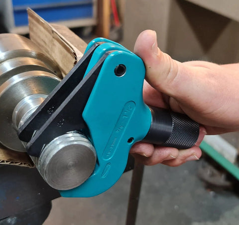 Universal Thread Repair Tool And Restorer For All Threads In Range Five Eighths Inch To One And A Half Inches External Or Internal Threads Metric And SAE One Hand Tool Quick Sizing Chases And Repairs Threads being used on a metallic object.