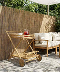 Premium Bamboo Serving Trolley Featuring Slick Smooth Rolling Casters For Easy Room To Room Transit And A Rock Solid Mobile Bar Or Kitchen Rolling Cart Option Built To Conquer Your Daily Grind Without Breaking A Sweat, with drinks, outdoors.