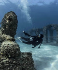 Diver using Beefy Dive Light With 850 Lumen Output, Eight Beam Angle, exploring underwater wreck with rugged matte black aluminum body.