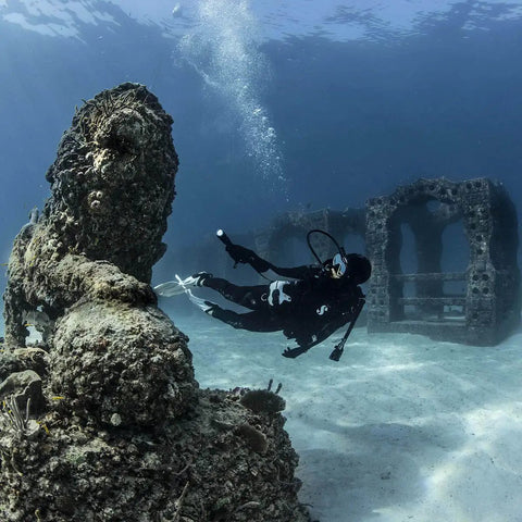 Diver using Beefy Dive Light With 850 Lumen Output, Eight Beam Angle, exploring underwater wreck with rugged matte black aluminum body.