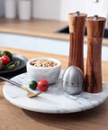 12 Inch Solid Marble Lazy Susan Turntable With Buttery Smooth Swivel Base For Zero Fuss Kitchen Countertop Organization featuring spices and utensils.