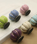 Super Slick Vintage Ceramic Pumpkin Cabinet Knobs 6 Piece Set in assorted colors on a surface, showcasing stylish drawer pulls for cabinets.