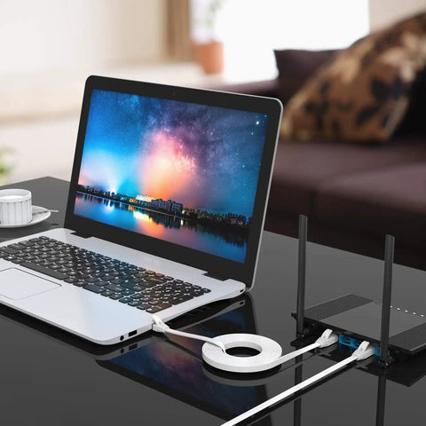 Flat Cat6 Ethernet Cable 20 Ft White RJ45 Patch Cord for Gigabit LAN Network With Fast Speeds, connected to laptop on desk