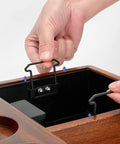 Hand adjusting the integrated knock box in the Solid Wood Espresso Tamper Holder Combo With Integrated Knock Box And Grounds Bin.