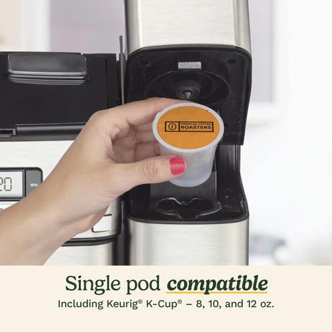 Hand placing coffee pod into All In One Grind And Brew Coffee Center With Built In Grinder Coffeemaker And Single Serve Brewer In Black And Silver