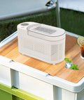 Fast Freeze Mini Countertop Ice Maker Features A Clear Viewing Lid While You Watch Crisp White Cubes Drop Right Out on a wooden tabletop.