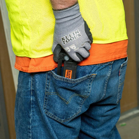 Person with glove holding tool in back pocket wearing workwear