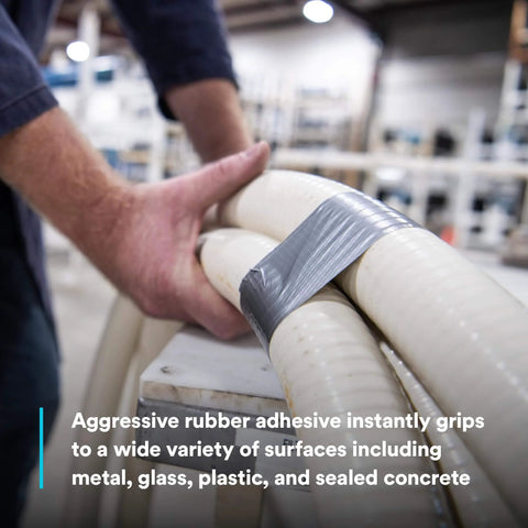 Person using Heavy Duty Duct Tape DT11 Silver 48 mm x 54.8 m (11 mil) on pipes, demonstrating aggressive rubber adhesive.