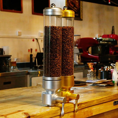 Sick Wall Mount Coffee Bean Dispenser Heavy Hitter Acrylic Canister with silver and gold finish holding coffee beans