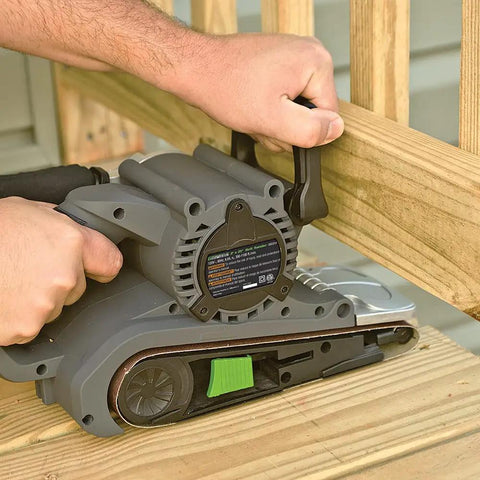 Single Lever Belt Sander 3 Inch By 21 Inch Variable Speed used on wood deck by person, showing adjustable handle and dust bag attachment.