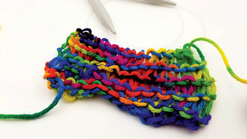 Close-up multicolor yarn swatch with twisted rainbow yarn strands on white background