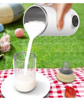 Grab And Go Heated Self Stirring Mug Electric Magnetic Mixing Travel Cup pouring milk into a glass outdoors on grass.