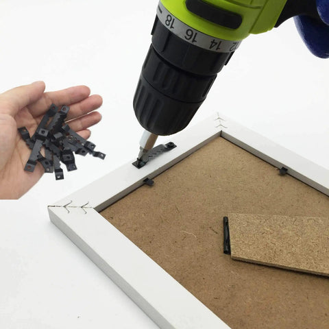 Steel Sawtooth Picture Hangers With Screws 50 Pack for Frames Clocks Paintings being installed on a white frame with a drill.