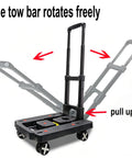 Black car seat dolly travel cart with foldable frame, rotating tow bar, four wheels, and adjustable handle.