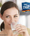 Person drinking water filtered by Maxtra Plus Replacement Water Filter Cartridges, smiling with badge showing 'Since 1966' in background.
