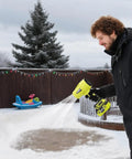 Person using Cordless Turbo Jet Leaf Blower for lawn debris, driveway sand, and car drying, 450 CFM high speed in snowy yard.