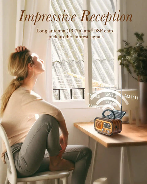 Woman at table with J-150 Portable Radio AM FM SW Bluetooth Speaker with retro look and solar USB charging shown in sunlight
