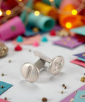 Top Tier 100 Pack 8mm Slotted Phillips Head Screw Brads In Sleek Silver for scrapbook, featuring one shiny silver brad on a colorful background.