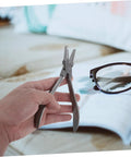 Hand holding pliers next to glasses, Stainless Steel Two Piece Eyeglass Repair Kit With Flat Nose Pliers And Precision Screwdriver