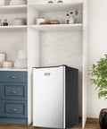 Solid 3.2 Cu Ft Upright Mini Freezer With No Stress Adjustable Thermostat And Removable Shelves For Dorm Office Kitchen Or Bedroom Smooth Chill Stash Setup In Fresh Silver in a modern kitchen setting.
