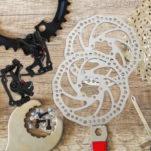 Heavy Duty Mechanical Disc Brake Kit With Front And Rear Rotors And Thick Pads For Mountain Bike on wooden surface, showing rotors and calipers.