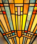 Close-up of a Tiffany Style Wall Sconce With Stained Glass Shade showcasing intricate geometric stained glass patterns.