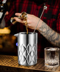 Kickback Ready 18 Oz Stainless Steel Cocktail Mixing Glass with weighted base, pouring liquor for martini mixing.