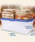 Straight Up Heavy Duty 113 Qt Long Storage Bin With Secure Snap On Lid, Crystal Clear Stackable Plastic Tote For Bulky Blankets And Seasonal Gear, Rock Solid Zero Fuss Garage Organizer stacked with folded blankets.
