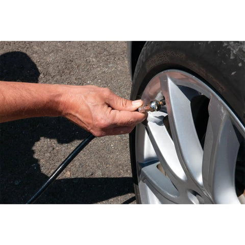 Hand using Four Ft Rugged Pvc Air Hose With Snap On Tire Chuck Rated At Three Hundred Psi For Everyday Yard Work And Garage Hacks to inflate tire.