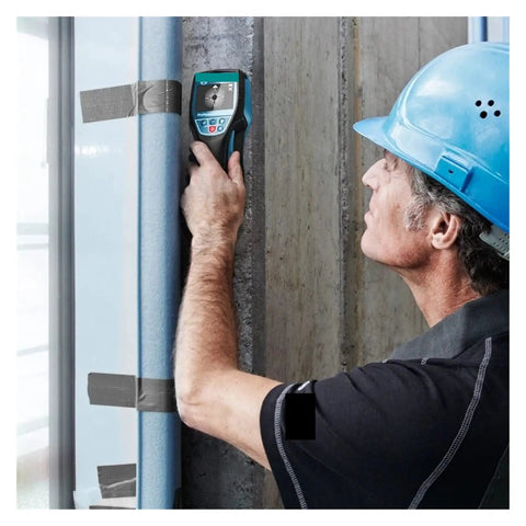 Man using Killer Pro Wall Scanner And Digital Stud Finder on concrete wall to locate wood, metal pipes, and electrical cables.