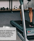 Close-up of a person using a treadmill showing Heavy Duty Anti Vibration Rubber Pads 4 Pack Shock Absorbing Base Mounts in use.