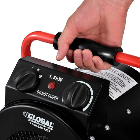 Close-up of hand holding Portable Electric Space Heater With Built In Thermostat And Ergonomic Handle 1500 Watt 5120 BTU