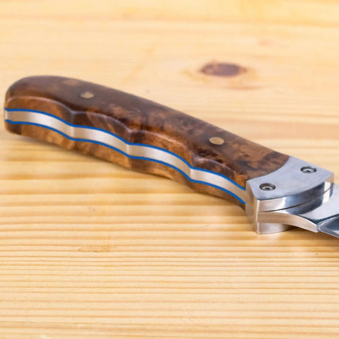 Close-up of knife handle with wooden scales and visible G10 Knife Handle Spacer Sheets 10 Pack For DIY Knife Scales Slabs in blue.