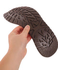2 Pack Heavy Duty Rubber Sole Replacement Patches For Work Boots And Casual Sneakers in dark brown, held in hand.