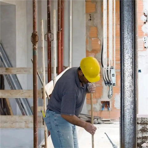 Rope Pulley Hoist System With Six To One Lifting Power And 2200 Pounds Breaking Strength Wooden Handle Construction worker using rope pulley hoist