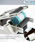 Smooth Operator Semi Automatic Round Bottle Labeler delivering labels to cylindrical bottles in a desktop setup.