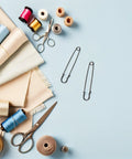 Luxurious Heavy Duty Safety Pins For Women Thick Iron Sweater Clips for Scarves and DIY Crafts on a light blue background.