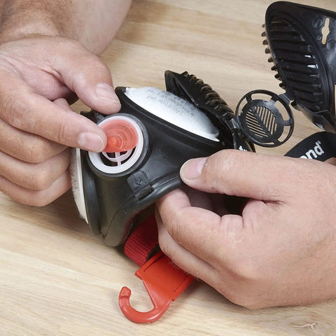 Hands assembling Air Stealth Dust Mask Respirator M/L With Replaceable HEPA Filters For Construction And Job Site Work
