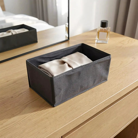 Super Sturdy Foldable Drawer Clothing Organizer Set Eight Piece Gray Fabric Wardrobe Dividers with folded item on a dresser.