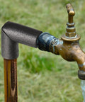 Black elbow insulation foam tube installed on outdoor brass faucet, part of 8 Pack Black Elbow Pipe Insulation Foam Tubes For Outdoor Use Easy Install Weatherproof Pipe Covers And Insulation Tubing For Water Lines Sprinklers And Irrigation Systems 1 Inch Fit For Outdoor Winter Protection.