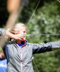 Person aiming bow with 20 Pack Feather Arrow Fletchings 4 Inch Turkey Vanes for Hunting and Target Shooting in a garden setting