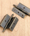 Antique Bronze Hinges Set For Wood Boxes And Cabinets, Vintage Style Door Hardware With 16 Screws, 8 Hole Crown Design on wood surface