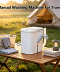 Portable Manual Crank Washing Machine Cordless Laundry Setup Eight Liter Capacity with laundry basket at campsite